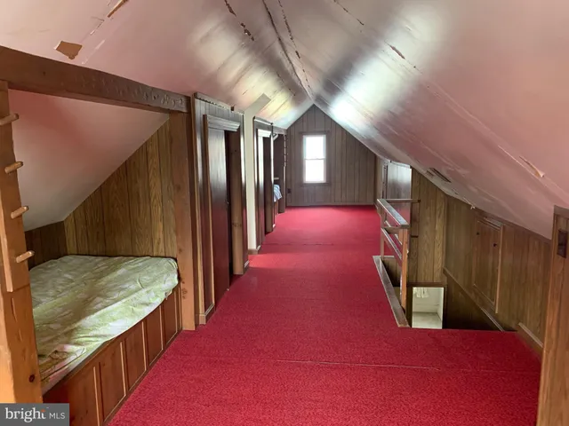 a view of an empty room with stairs and a window