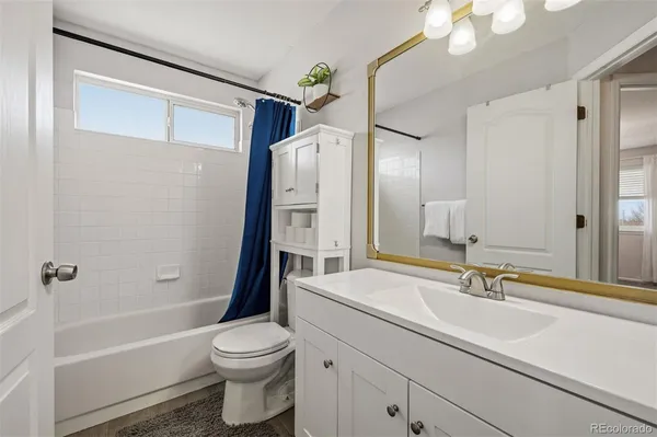 a bathroom with a sink a toilet a mirror and shower