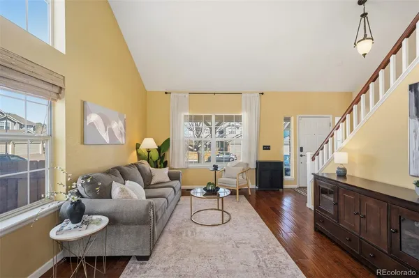 a living room with furniture large window and wooden floor