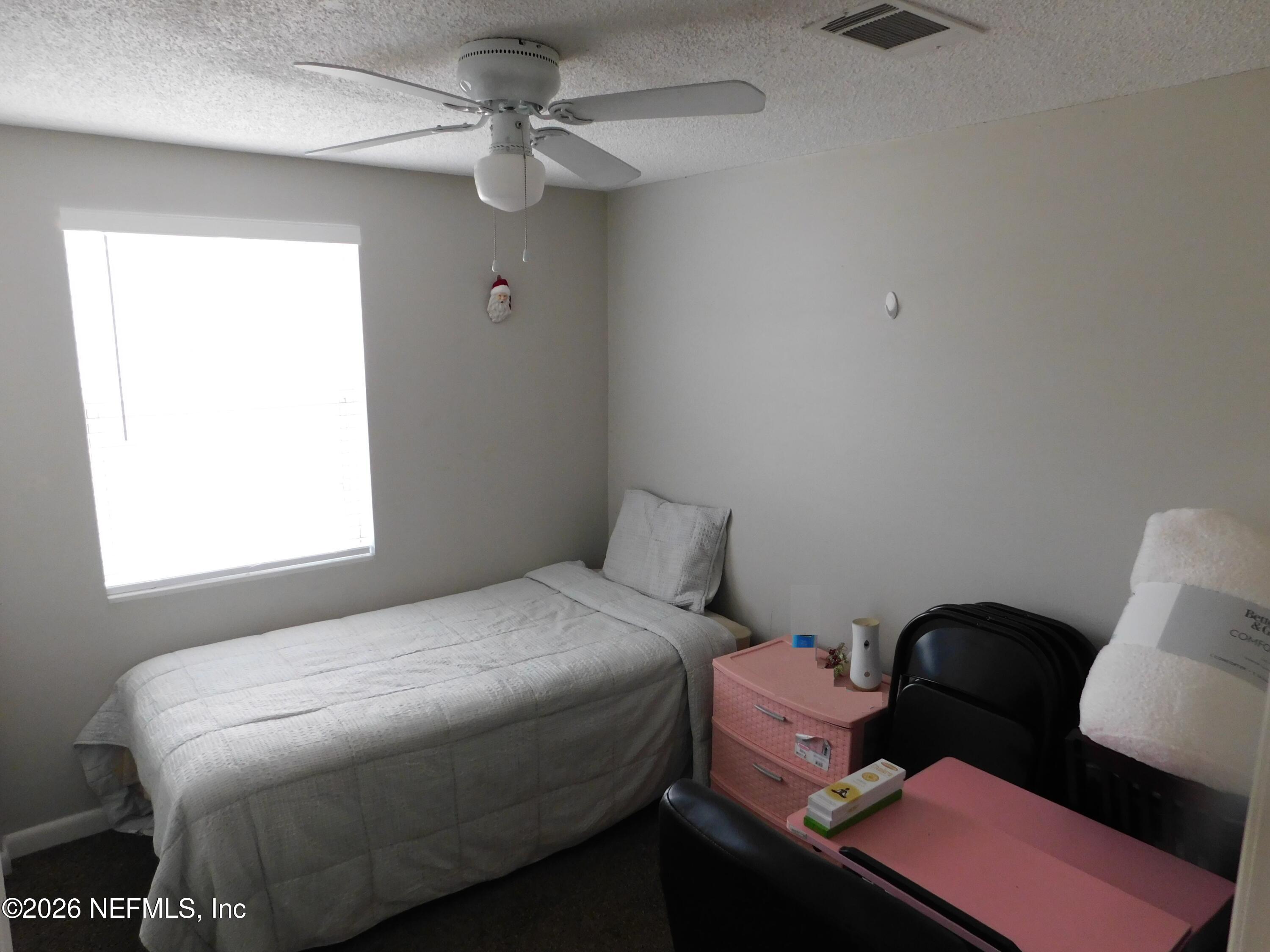 2798 Commanche Avenue Orange Park, FL 32065 - Photo 8 of 42 a bedroom with a bed and a chair