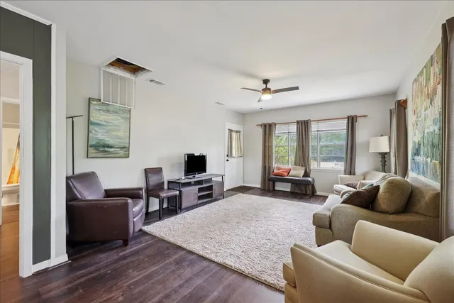 a living room with furniture and a flat screen tv with wooden floor