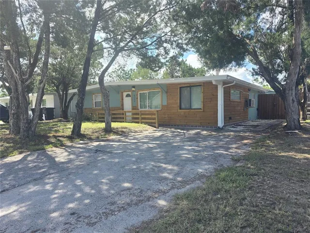 a view of a house with a yard covered in the forest