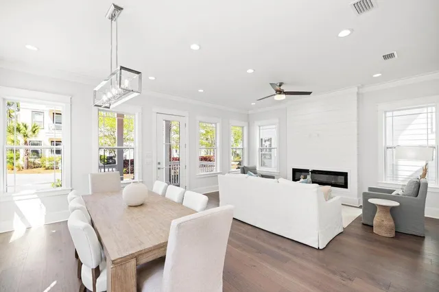 a living room with furniture large window and wooden floor