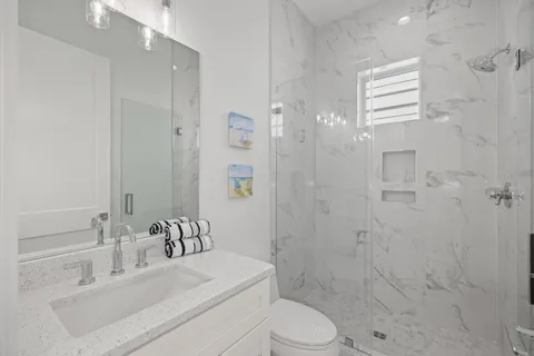 a bathroom with a toilet a sink and mirror