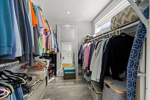 a view of walk in closet with clothes