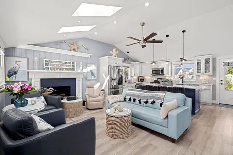 a living room with furniture a fireplace and a chandelier