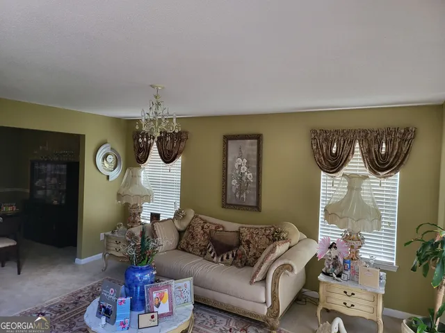 a living room with furniture and a chandelier