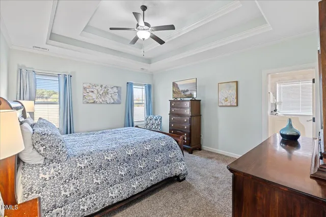 a bedroom with a large bed a chandelier and a dresser