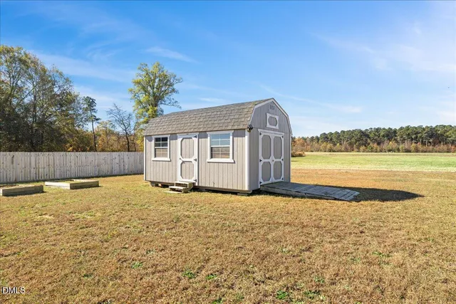 a view of a house with a yard and a large tree