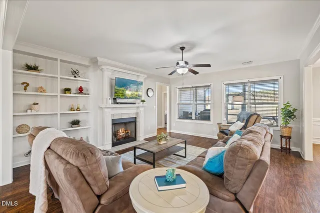 a living room with furniture a fireplace and a large window