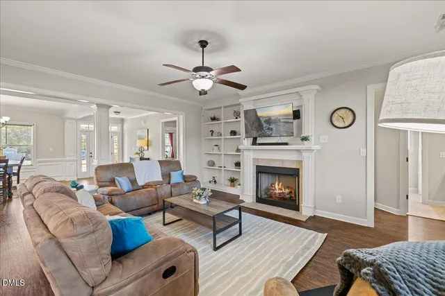 a living room with furniture a fireplace and wooden floor