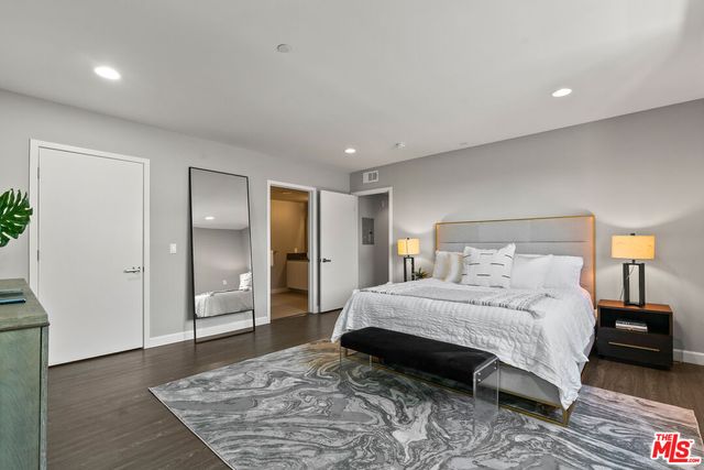 a bedroom with a large bed and wooden floor