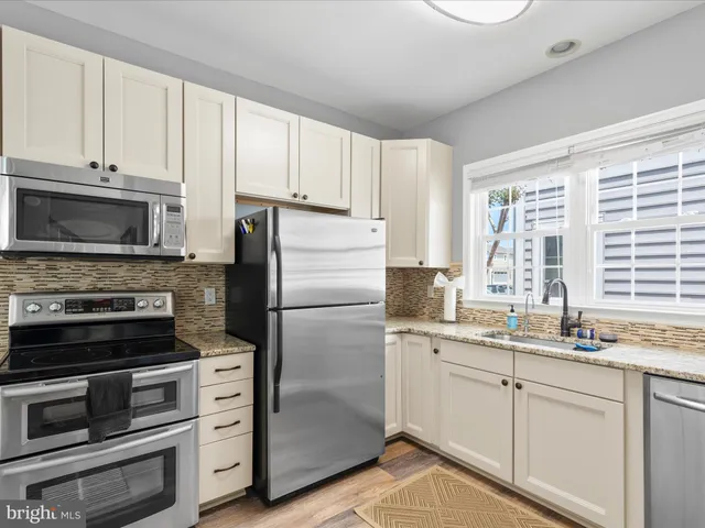 a kitchen with appliances a sink and cabinets
