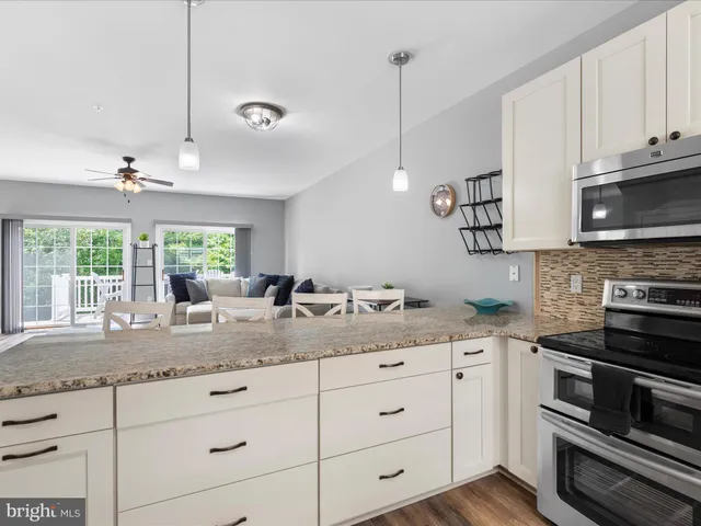 a kitchen with granite countertop stainless steel appliances a stove sink and microwave