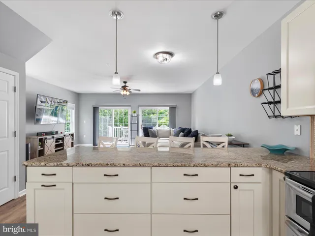 a kitchen with granite countertop cabinets a stove a sink a dining table and chairs