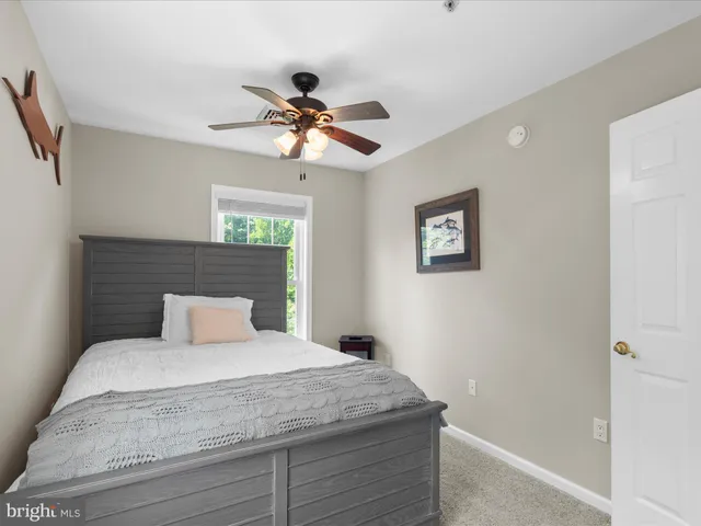 a bedroom with a large bed and a ceiling fan