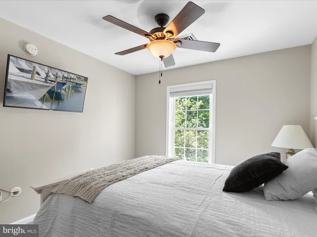 a bedroom with a bed window and a ceiling fan