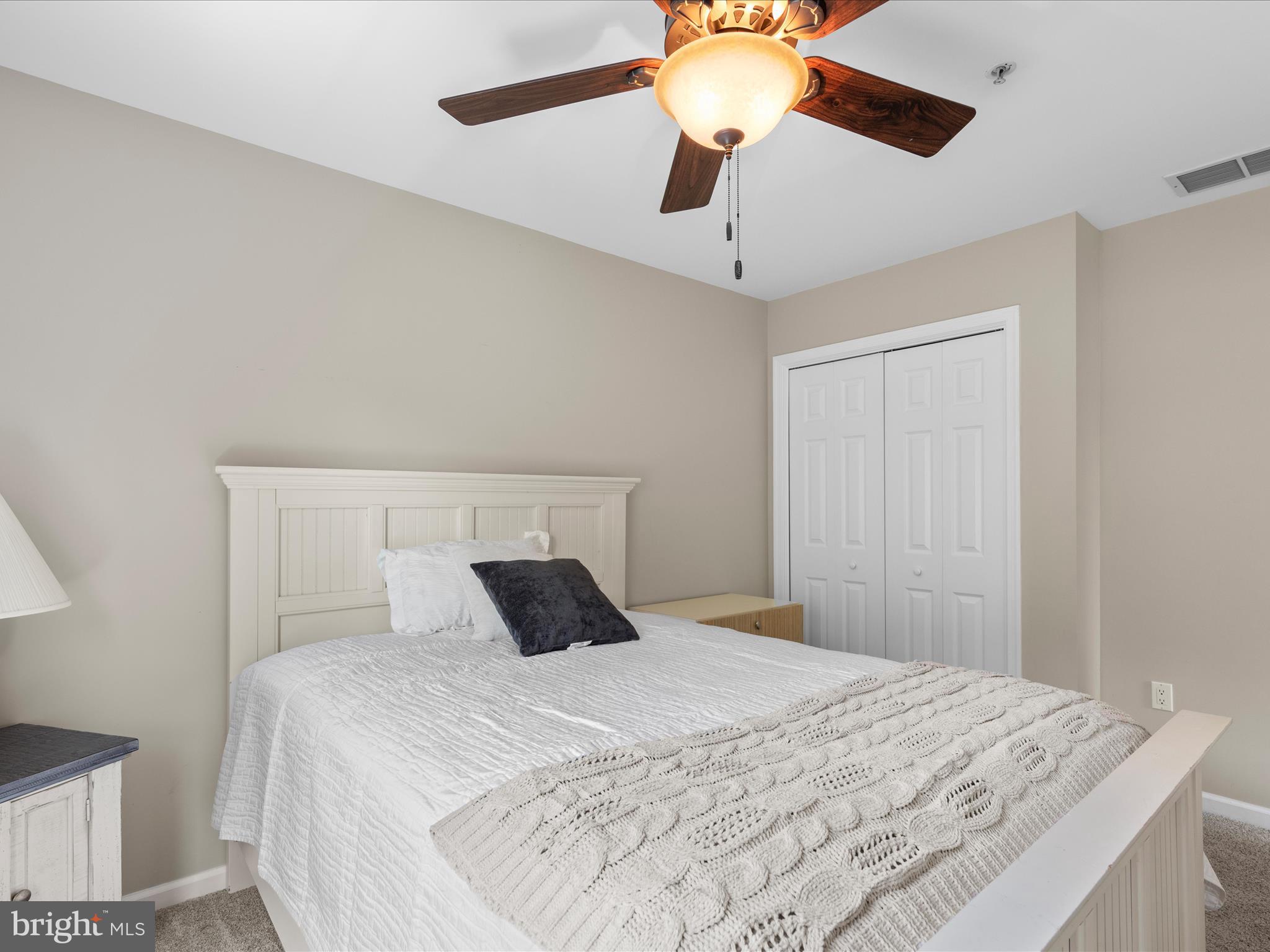 9739 Golf Course Road, Unit D102 Ocean City, MD 21842 - Photo 36 of 42 a bedroom with a bed and a chandelier