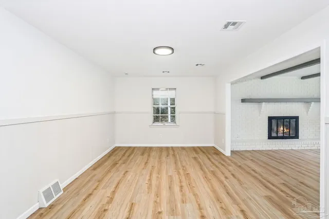 a view of a room with wooden floor and a window