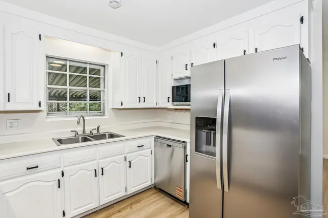 a kitchen with a refrigerator sink and cabinets