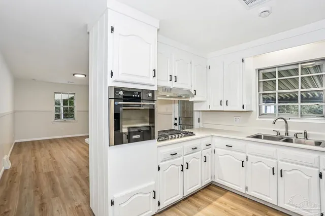 a kitchen with granite countertop white cabinets and white appliances