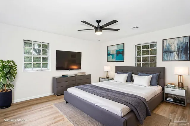 a bedroom with a large bed and a flat screen tv