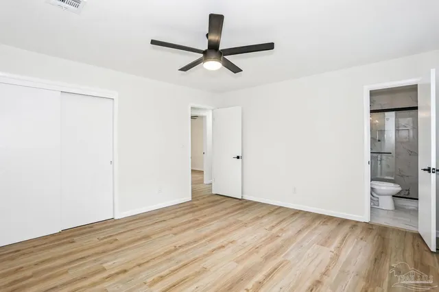 a view of a room with wooden floor and a ceiling fan
