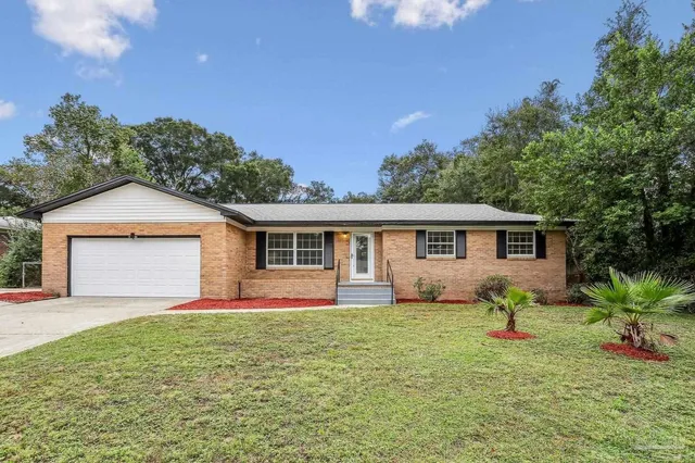 a front view of a house with a yard and trees