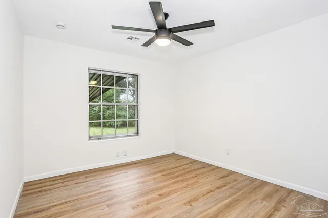 a view of a big room with wooden floor and a ceiling fan