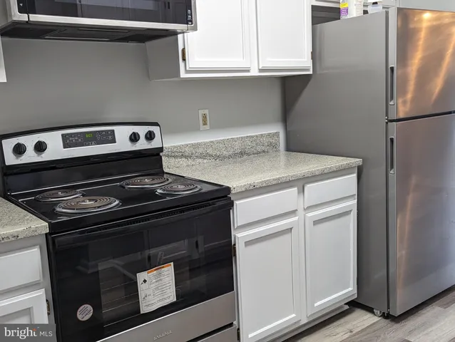 a stove top oven sitting inside of a kitchen