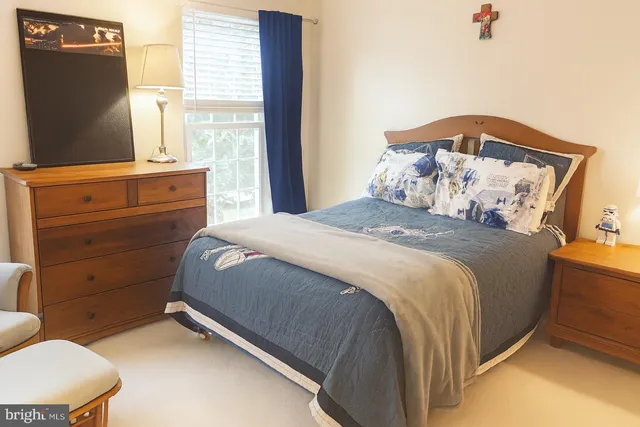 a bedroom with a bed and a flat tv screen on dresser