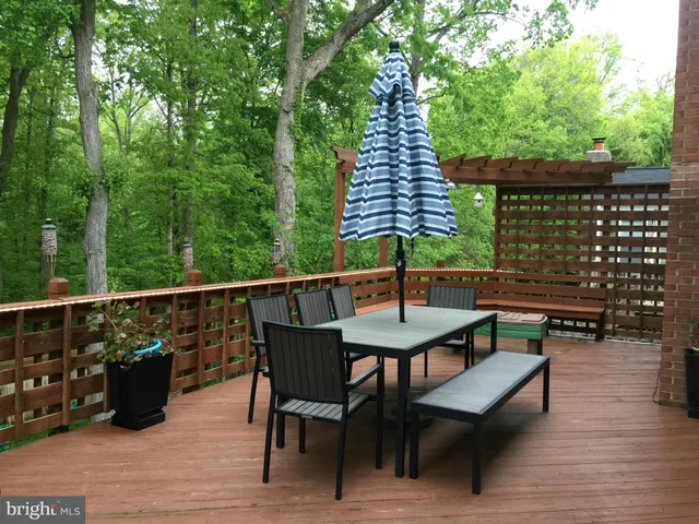 a balcony with wooden floor table and chairs