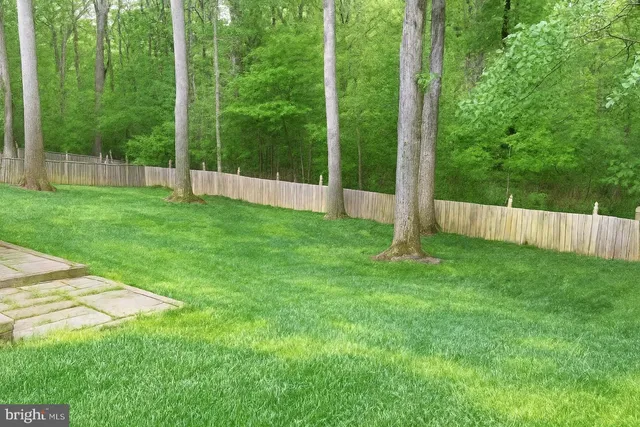 a view of a yard with a fence and trees