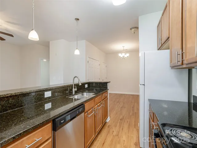 a kitchen with granite countertop a sink a counter space and cabinets