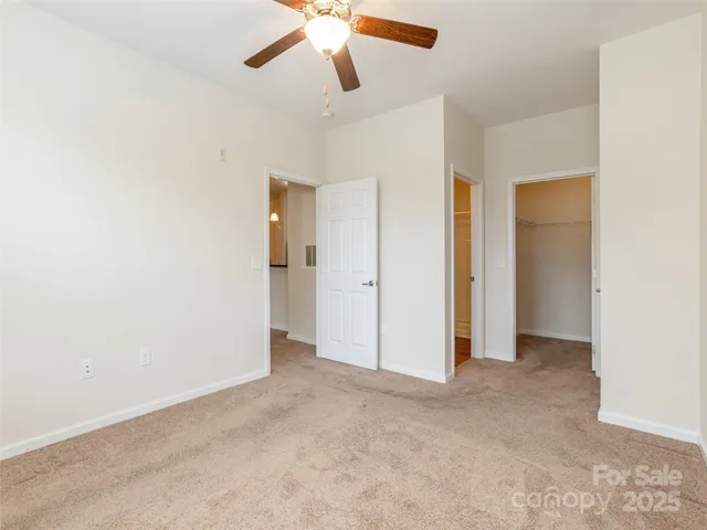 an empty room with closet and windows