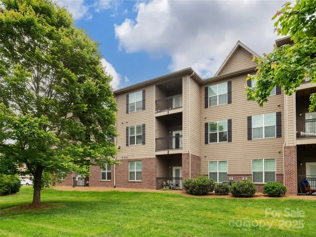 a front view of a house with a garden and trees