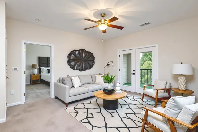 a living room with furniture a chandelier and a window