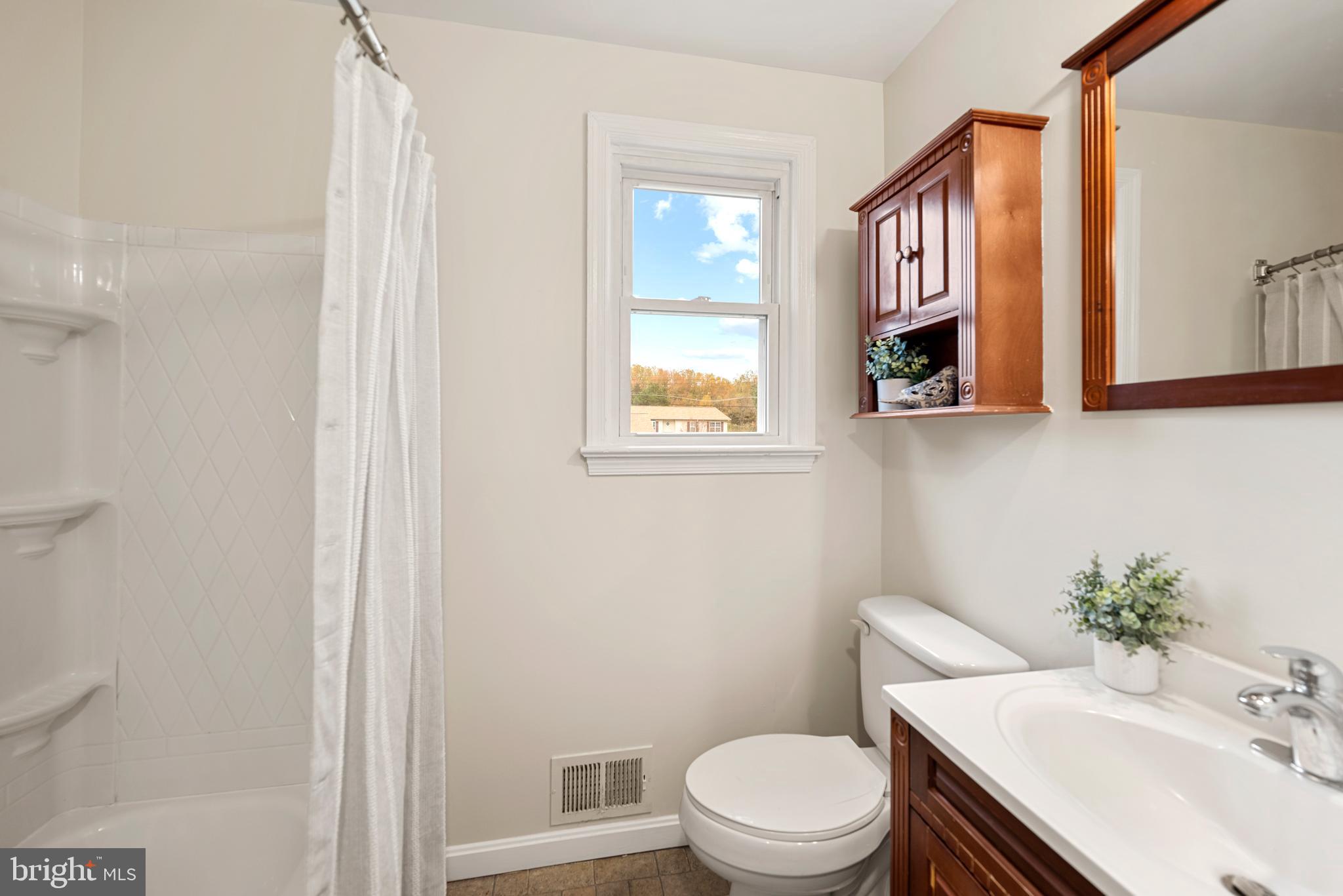 7807 Colonial Lane Clinton, MD 20735 - Photo 14 of 29 a bathroom with a toilet a sink and a window
