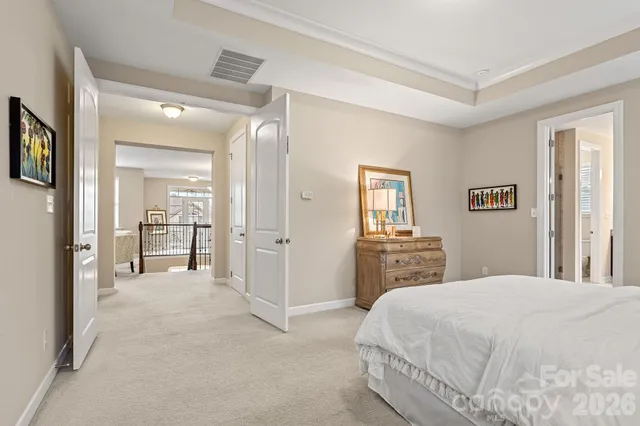 a bedroom with a large bed and a chandelier
