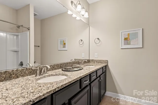 a bathroom with a granite countertop sink a large mirror and vanity