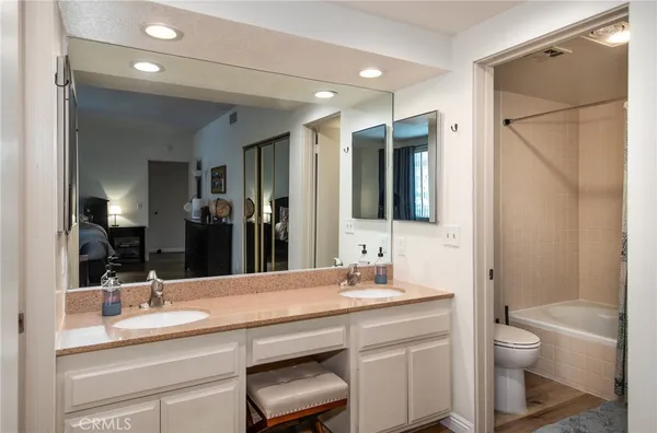 a bathroom with a double vanity sink toilet and shower
