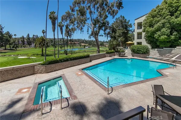 a view of a swimming pool with lawn chairs and a big yard