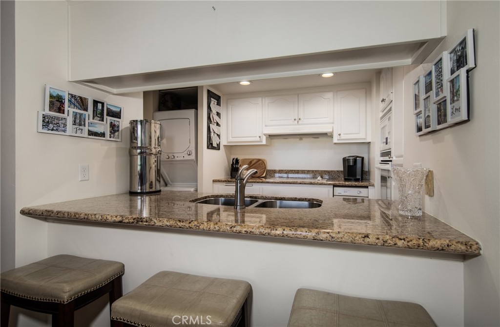 5555 Canyon Crest Drive, Unit 2G Riverside, CA 92507 - Photo 3 of 24 a kitchen with stainless steel appliances granite countertop a sink and a refrigerator