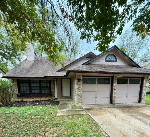 a front view of a house with a garden and yard