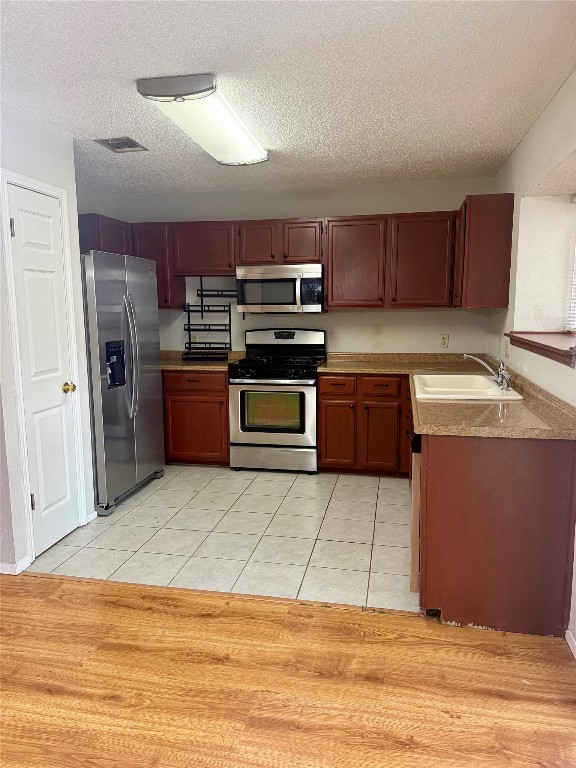 1707 Honeysuckle Lane Round Rock, TX 78664 - Photo 7 of 21 a kitchen with stainless steel appliances granite countertop a refrigerator and a stove top oven