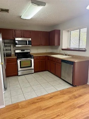 a kitchen with stainless steel appliances granite countertop a stove a sink and a microwave