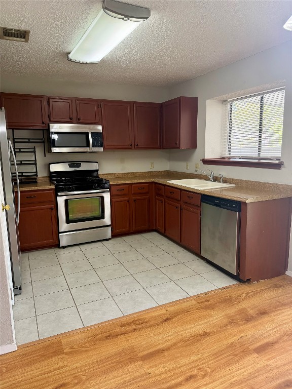 1707 Honeysuckle Lane Round Rock, TX 78664 - Photo 8 of 21 a kitchen with stainless steel appliances granite countertop a stove a sink and a microwave