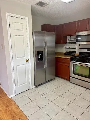 a kitchen with granite countertop a refrigerator and a sink
