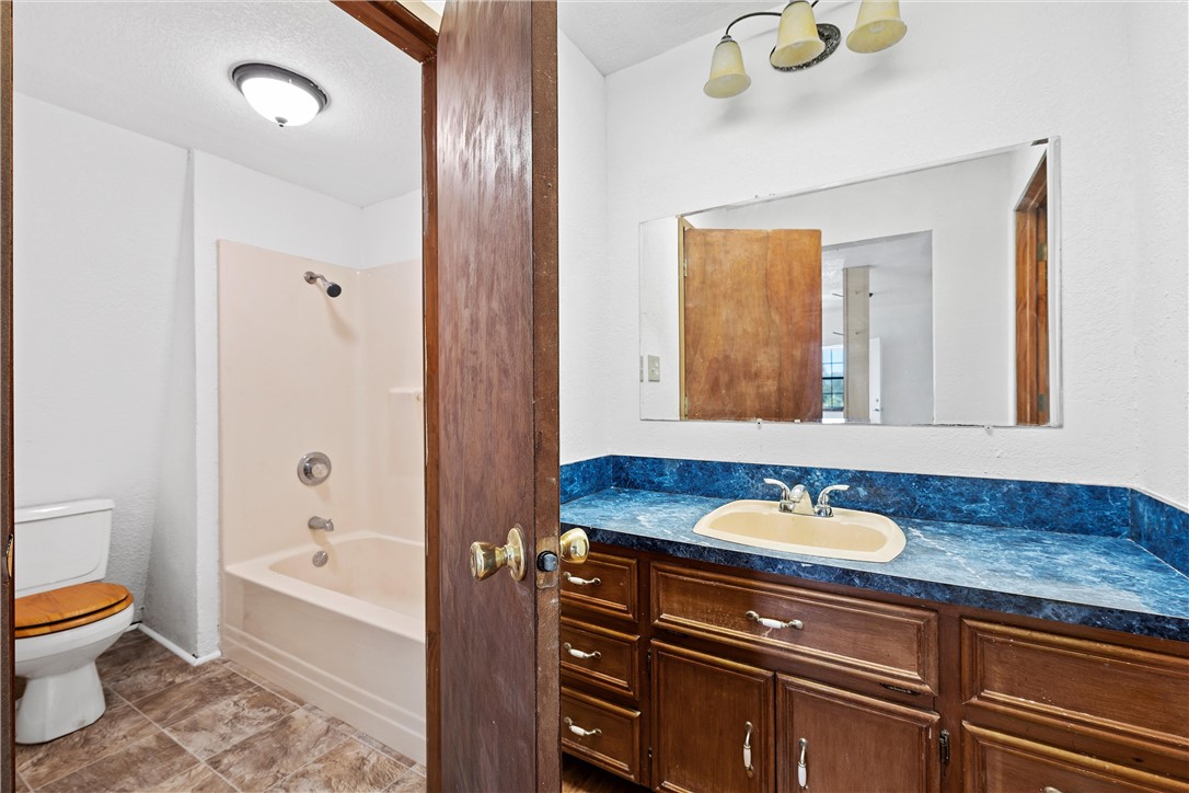821 Old Country Road Moody, TX 76557 - Photo 12 of 21 a bathroom with a granite countertop sink toilet and shower
