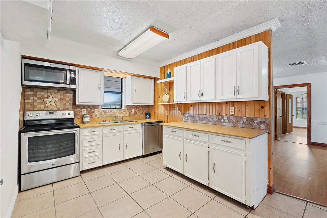 821 Old Country Road Moody, TX 76557 - Photo 6 of 21 a kitchen with granite countertop white cabinets and white appliances